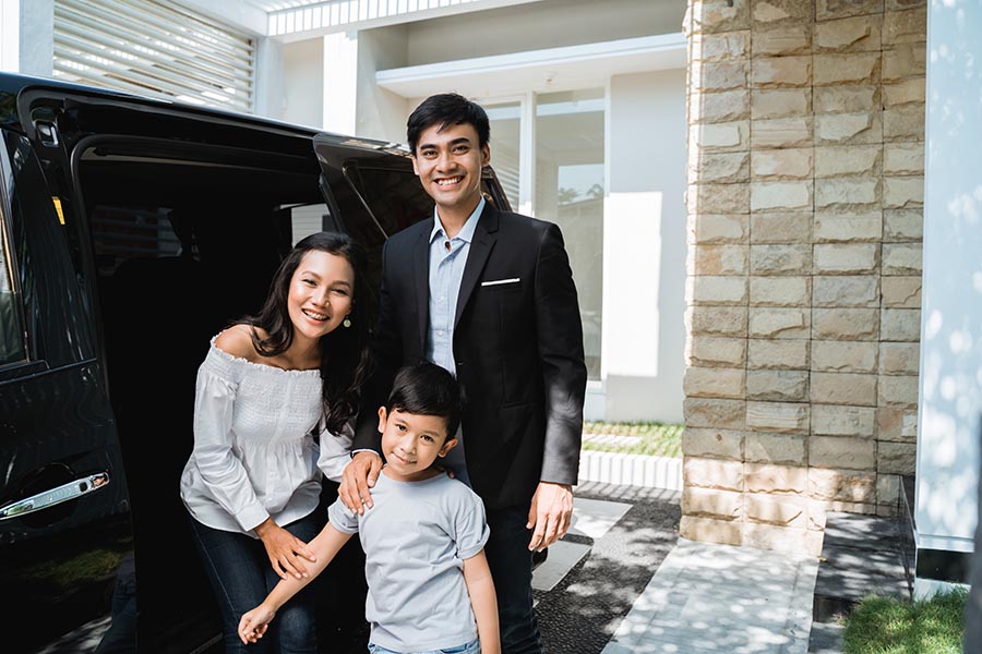 Personal Insurance - Parents and Young Son Standing by Their Black SUV in Front of Their Home